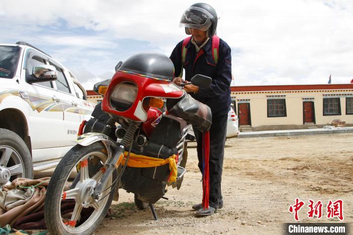 圖為白瑪準備騎摩托車巡湖?！≮w朗 攝