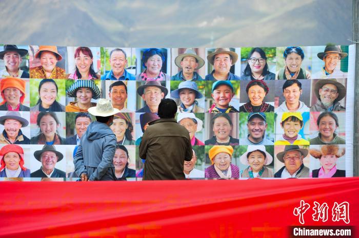 圖為當?shù)孛癖娫谟^看展板上的笑臉。　張偉 攝