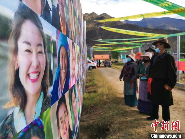 圖為當?shù)孛癖娫谟^看展板上的笑臉。　張偉 攝