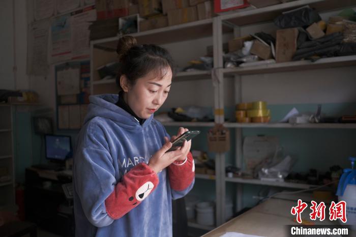 正在快遞站點(diǎn)內(nèi)忙碌的楊莉春?！『闻罾?攝