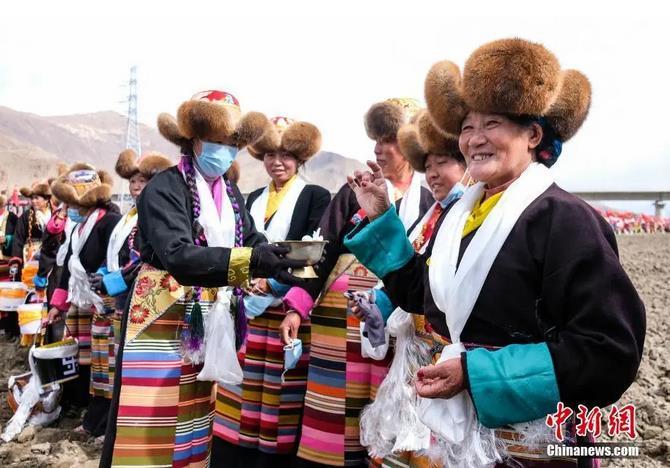 資料圖：西藏自治區(qū)拉薩市曲水縣才納鄉(xiāng)協(xié)榮村參加春耕儀式的村民互敬青稞酒。按照傳統(tǒng)，當(dāng)?shù)卮迕裆碇?jié)日盛裝，舉行隆重的儀式，祈福一年的豐收。<a target='_blank' ><p  align=