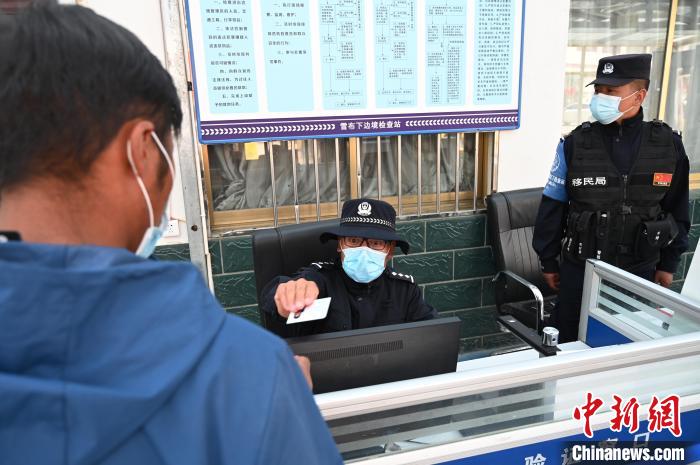 圖為移民管理警察登記完身份信息后將證件歸還給行人。　趙朗 攝