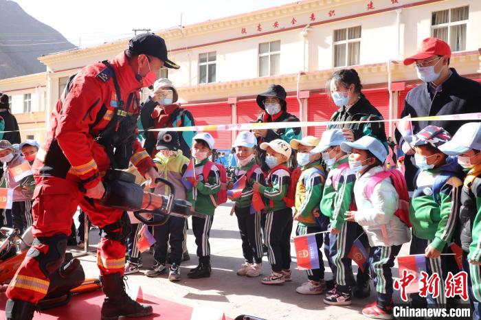 圖為消防指戰(zhàn)員為學(xué)生講解、演示先進(jìn)救援裝備?！≮w琳 攝