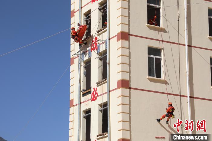 圖為消防指戰(zhàn)員進(jìn)行繩索救援演練。　朱科熹 攝