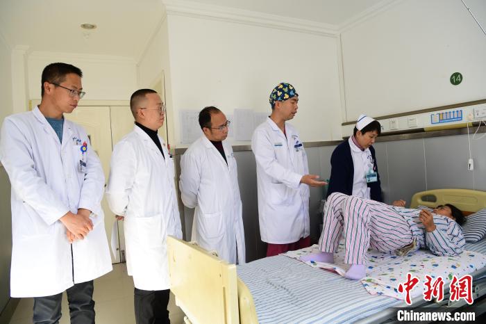 圖為何蔚副主任醫(yī)師(站右二)及團隊術(shù)后指導(dǎo)患者進行腰背肌鍛煉?！∝暩聛硭?攝