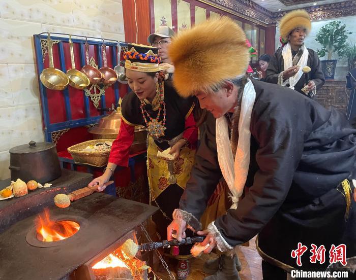 圖為人們?cè)诨鹕峡竟?jié)日美食“結(jié)達(dá)”?！∪轿木?攝