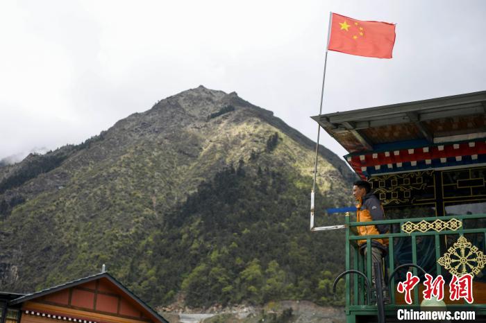 村民站在樓房上觀望?！钊A峰 攝