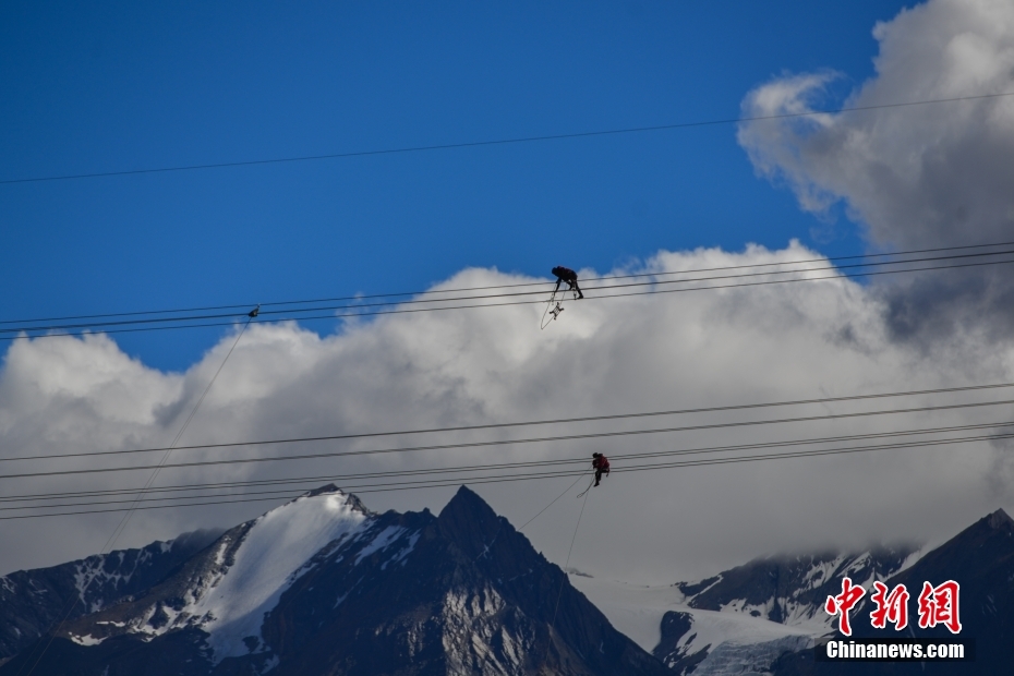 資料圖為2020年6月23日，西藏阿里聯(lián)網(wǎng)工程施工人員在日喀則希夏邦馬雪山附近進行走線作業(yè)，安裝絕緣設(shè)備。 <a target='_blank' href='/'><p  align=