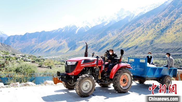 圖為工作人員將把加工完成的糌粑運(yùn)送至村民手中?！〖卫杩h融媒體中心供圖