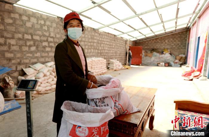 圖為寧重崗村村民扎西才措把自家的油菜籽送到合作社銷售?！〖卫杩h融媒體中心供圖