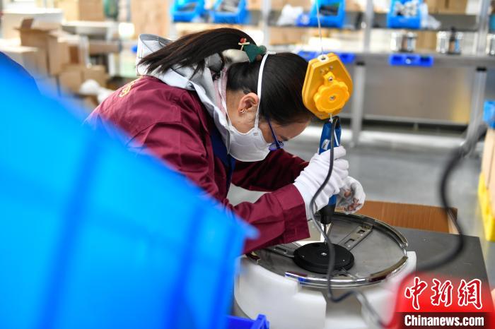 圖為工人正在組裝炊具?！∝暩聛硭?攝