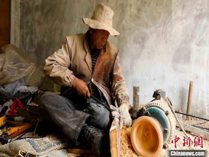 圖為手工藝人正在制作木碗?！?鄧海平 攝