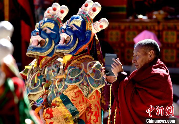 2月19日，正在拍攝跳神活動(dòng)的僧人。　李林 攝