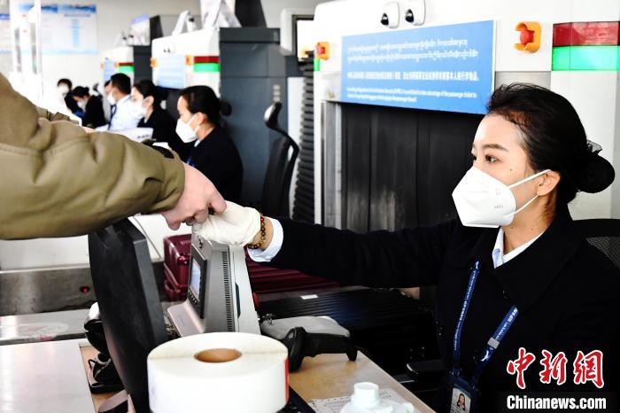 圖為機場工作人員為旅客辦理行李托運?！≈芎?攝