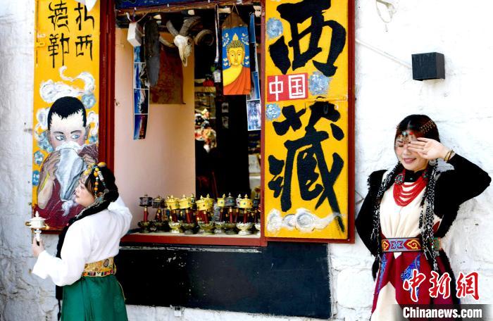 4月17日，游客身著藏式元素服裝在拉薩八廓街拍照留念。　李林 攝