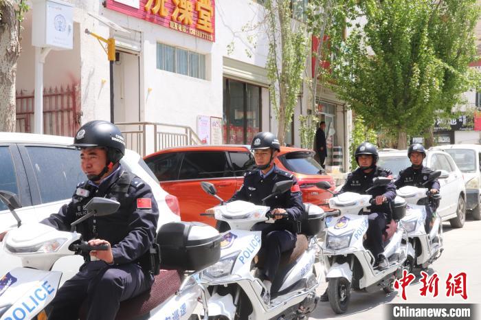 民警騎著電瓶車在轄區(qū)巡邏走訪。　黃創(chuàng)偉 攝