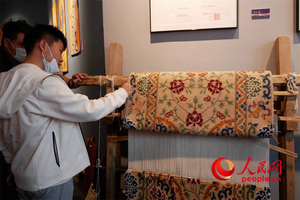 觀眾正在觀賞展出的藏毯。人民網(wǎng) 韋衍行攝