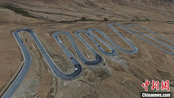 圖為騎手前往珠峰大本營(yíng)途經(jīng)108道拐?！∮文恋厍蚬﹫D