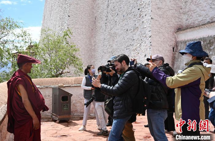 圖為中外媒體拍攝朝拜布達(dá)拉宮的僧人?！≮w朗 攝