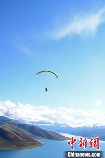 圖為在羊卓雍錯(cuò)，游客體驗(yàn)高空滑翔?！≮w朗 攝