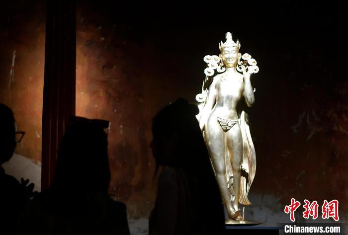 圖為觀眾正在欣賞展覽中的雕塑作品《八萬四千年》?！±盍?攝