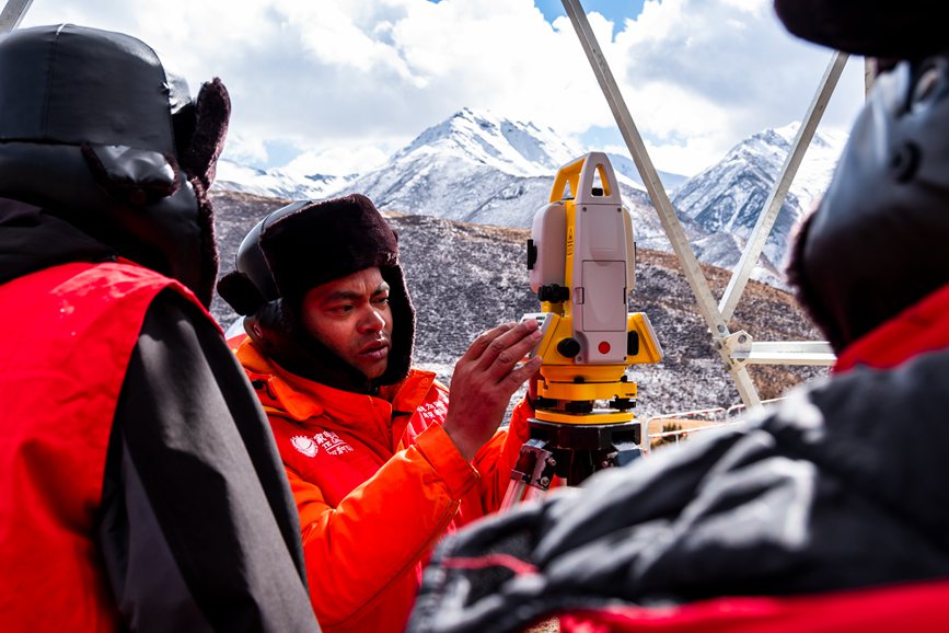 2023年11月30日，西藏自治區(qū)那曲市索縣榮布至丁青縣巴達(dá)35千伏線路工程負(fù)責(zé)人黃小洪（左二）現(xiàn)場開展線路弧測量教學(xué)。趙清鵬攝