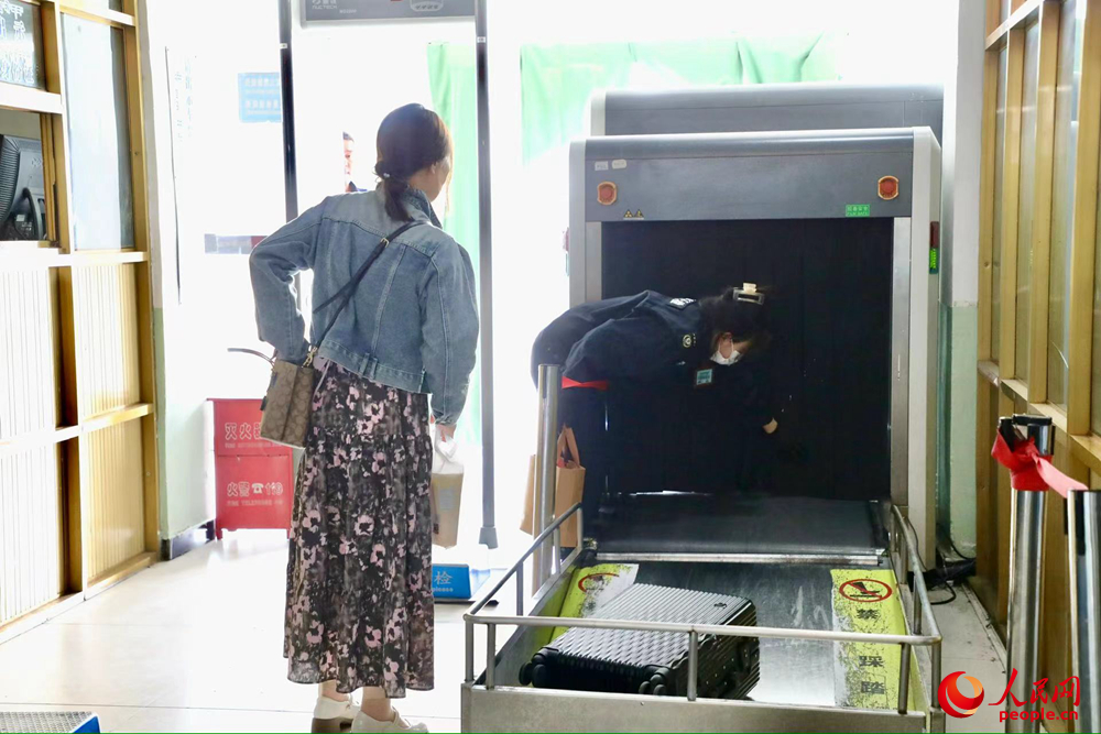 車站工作人員幫旅客提取行李。人民網(wǎng)記者 次仁羅布攝