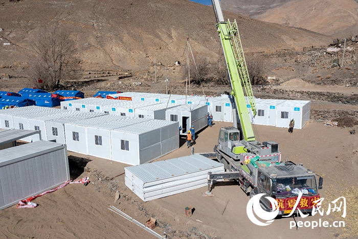 1月9日，在日喀則市定日縣長(zhǎng)所鄉(xiāng)古榮村安置點(diǎn)，救援人員和施工人員合力抓緊搭建移動(dòng)板房，確保受災(zāi)群眾溫暖過冬。人民網(wǎng)記者 翁奇羽攝