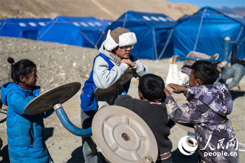 西藏星光社會工作服務中心社工久米旦增通過聊天談心，對孩子們進行災后心理疏導。人民網(wǎng)記者 翁奇羽攝