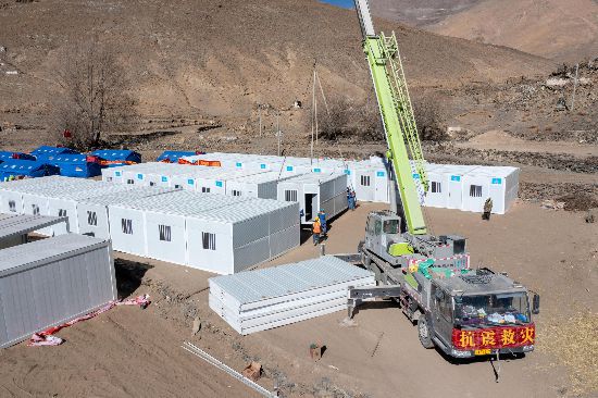 2025年1月9日，在定日縣長所鄉(xiāng)古榮村安置點，救援人員和施工人員合力抓緊搭建移動板房，確保受災群眾溫暖過冬。人民網(wǎng)記者 翁奇羽攝