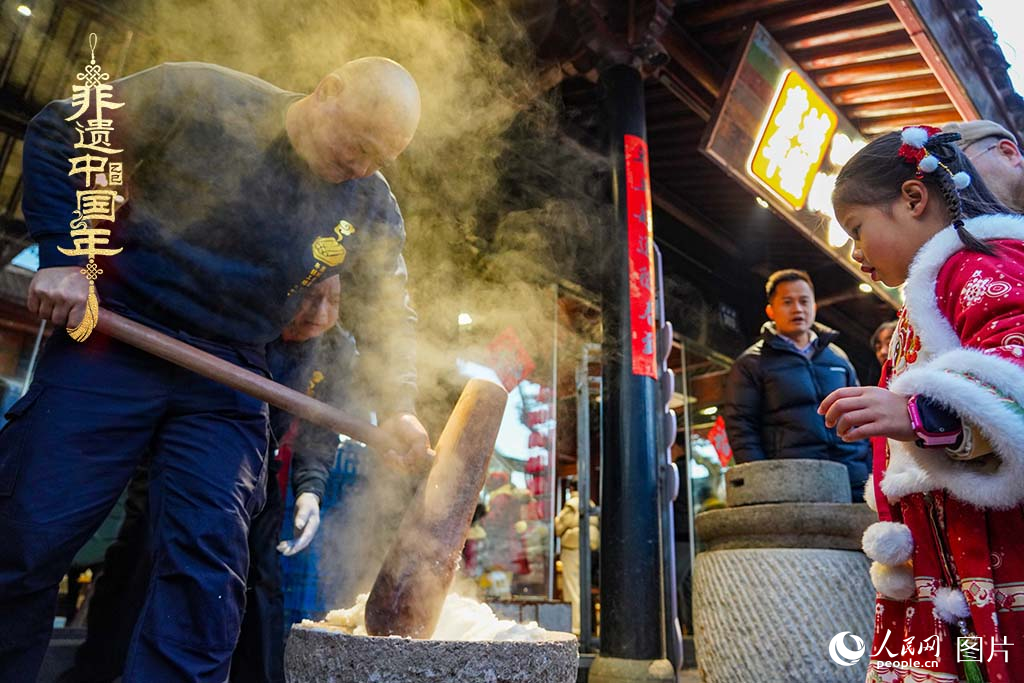 2025年1月29日，浙江省寧波市江北區(qū)慈城古縣城，市民和游客觀看搗年糕。人民網(wǎng) 章勇濤攝