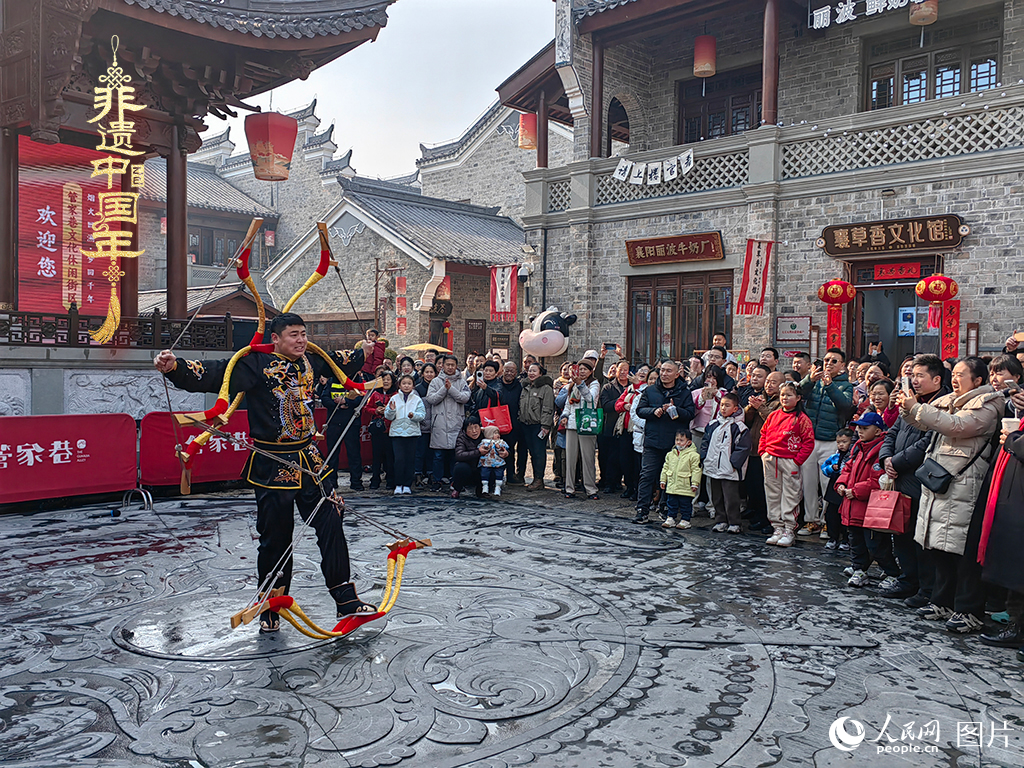 2025年1月29日，湖北襄陽(yáng)市管家巷，老北京天橋大刀張舉大刀拉硬弓第五代傳承人現(xiàn)場(chǎng)表演，一次拉開(kāi)6張弓，引來(lái)游客喝彩。人民網(wǎng)記者 郭婷婷攝