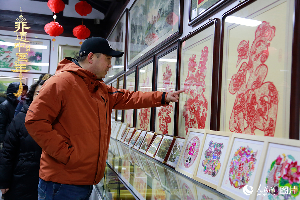 2025年1月23日，游客在天津楊柳青古鎮(zhèn)欣賞傳統(tǒng)剪紙作品，感受指尖上的古老藝術(shù)。人民網(wǎng)記者 崔新耀攝