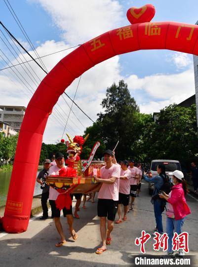 圖為5月29日，長(zhǎng)樂江田鎮(zhèn)村民們推著新龍舟前行?！埍?攝