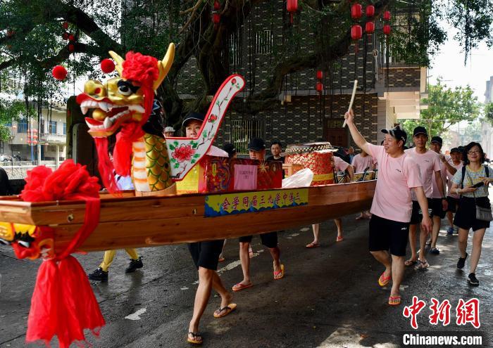 圖為5月29日，長(zhǎng)樂江田鎮(zhèn)村民們推著新龍舟前行?！埍?攝